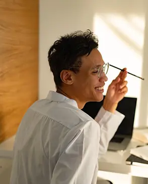 Person smiling with a laptop in the background